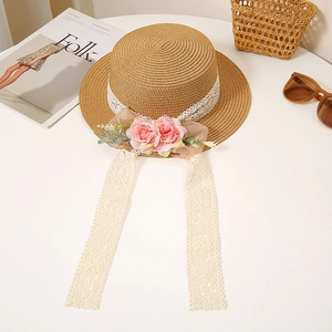 Close-up of lace ribbon with faux roses and tulle bow detail on a flat top straw hat