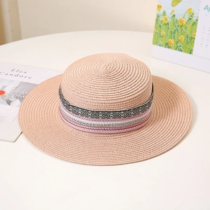 Detailansicht eines rosa Strohhuts mit flacher Krone und buntem Boho-Geometrie-Band