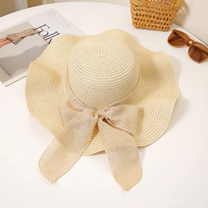 Detailed texture of hand-woven straw hat with elegant large bow on a white background