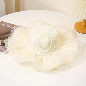 Détail d'un chapeau de paille élégant avec bord en organza blanc et perles