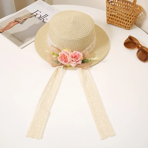 Detailed view of women's flat straw hat with pink fabric roses and lace ribbons
