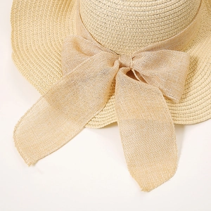Detailed macro view of large ribbon bow and fine straw weave texture on beach hat