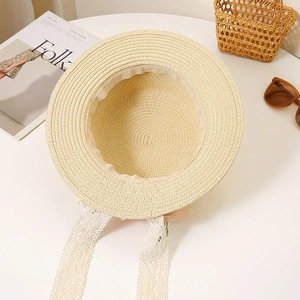 Flat top straw hat with delicate white lace ribbons and small floral details for summer