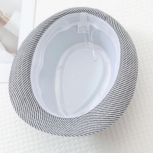 Detail of inner lining and 58CM size tag on black and white striped jazz hat
