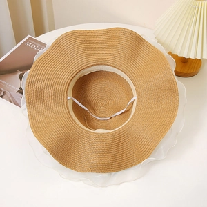 Détail d'un chapeau de paille à large bord avec bordure en organza blanc élégant