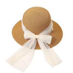 Straw sun hat with pearl ribbon bow for summer beach sun protection on white background