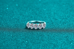 Macro shot of five sparkling round moissanite diamonds on a S925 sterling silver band