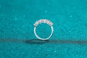 Macro shot of 925 sterling silver ring with five oval cut moissanite stones in prong setting