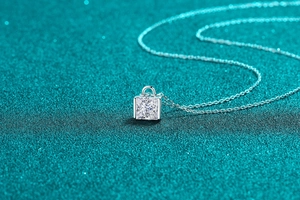 Vue macro du pendentif en moissanite de coupe carrée sur une fine chaîne en argent