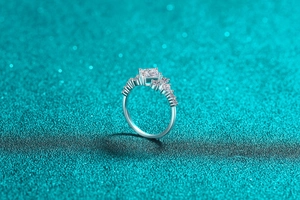 Detail of princess cut moissanite ring with side accent diamonds in silver S925 setting