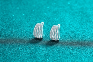 Macro shot of silver moissanite hoop earrings with pavé stones on glitter background