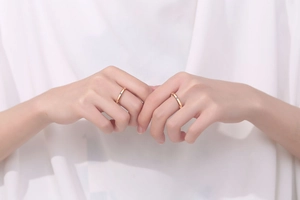 Close-up of minimalist rose gold couple rings featuring polished bands and tiny diamonds