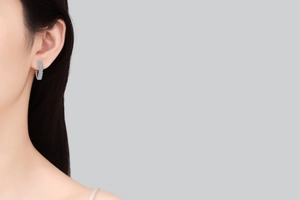 Gros plan de boucles d'oreilles créoles en argent 925 et moissanite portées par un mannequin