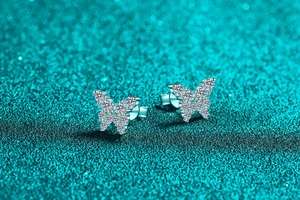 Macro shot of S925 silver butterfly earrings with sparkling white moissanite stones