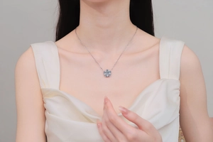 Close-up of a silver snowflake pendant necklace set with blue and white moissanite gems