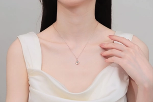 Détail du collier pendentif cœur en or champagne avec une pierre centrale bleu clair