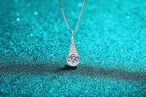 Close-up of S925 sterling silver pear-shaped pendant with round moissanite on box chain