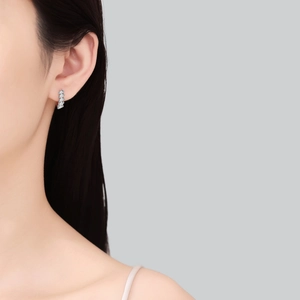 Elegant S925 sterling silver baguette moissanite earrings worn by a model on grey background