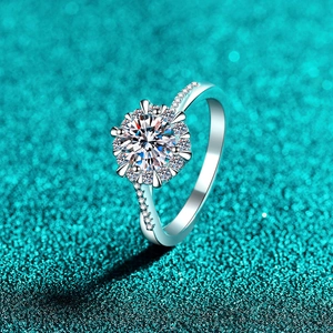 Bague halo en argent S925 avec moissanite et anneau pavé sur fond bleu sarcelle
