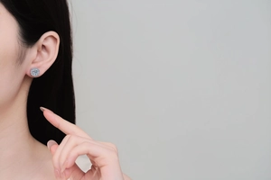 Close-up of elegant S925 sterling silver moissanite flower stud earring on model ear