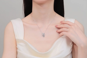 Gros plan du collier en argent S925 avec gemme bleue en cœur et pendentif en X