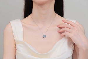 Close-up of S925 sterling silver necklace with a light blue sunflower pendant on a model