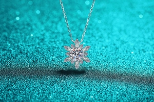 Macro view of snowflake pendant necklace with moissanite stones on blue glitter