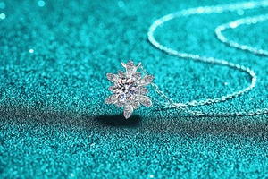 Macro shot of 925 sterling silver snowflake pendant with moissanite on blue background