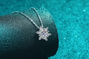 Macro shot of silver snowflake pendant featuring a brilliant moissanite stone in focus