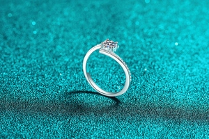 Detailed view of S925 silver moissanite ring with micro-pave accents on teal glitter