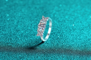 Macro shot of a sparkling round-cut moissanite ring with side star cluster accents