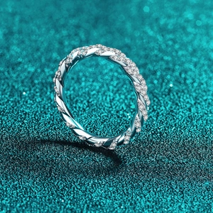 Bague torsadée en argent S925 avec moissanite et diamants pavés sur fond bleu sarcelle