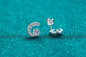 Détail de boucles d'oreilles C en argent 925 avec moissanite et pavé sur paillettes bleues