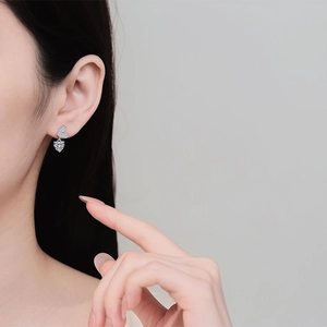 Orecchini a cuore in argento sterling S925 con moissanite indossati da una modella in primo piano