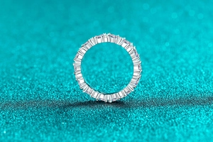 Detailed macro view of baguette and round-cut stones set in a silver eternity band