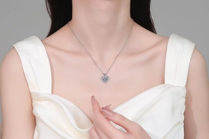 Close-up of S925 sterling silver heart pendant with sparkling moissanite on a model neck