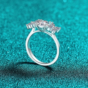 S925 sterling silver moissanite ring with five-stone setting on a blue glitter background
