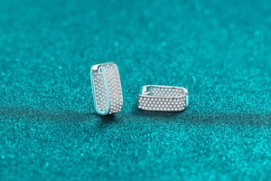 Macro detail of S925 sterling silver rectangular earrings with full pave moissanite stones