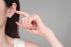 Gros plan d'une boucle d'oreille en moissanite carrée en argent S925 sur une oreille de femme