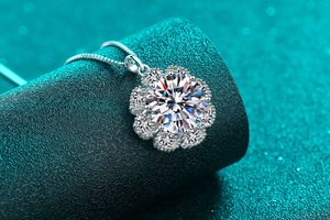Macro shot of silver sunflower moissanite pendant with sparkling center stone