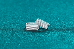Macro detail of S925 sterling silver square hoop earrings paved with sparkling moissanite