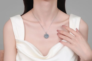 Detailed close-up of a silver sunflower moissanite necklace on a female model