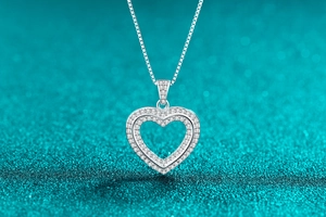 Macro shot of silver heart pendant with double-layered hollow design and pavé stones