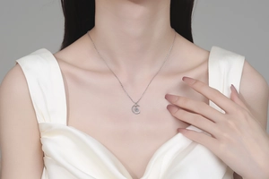 Close-up of S925 silver crescent moon pendant necklace with moissanite on a model