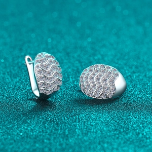 Sparkling S925 silver wave moissanite hoop earrings on a blue glitter background