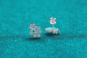 Macro shot of silver snowflake earrings with moissanite stones and butterfly backs