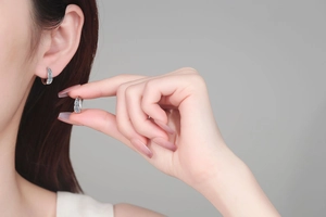 Detail of S925 silver hoop earrings with blue and white moissanite stones on ear