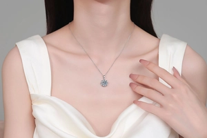 Detailed view of flower-shaped silver necklace with moissanite pendant on a model
