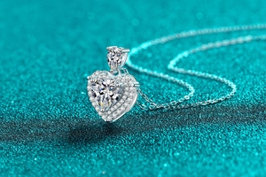 Macro side view of silver heart pendant featuring a large Moissanite and halo stones