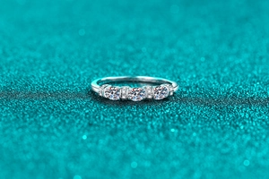 Close-up of S925 sterling silver ring with three round moissanite stones and small diamonds